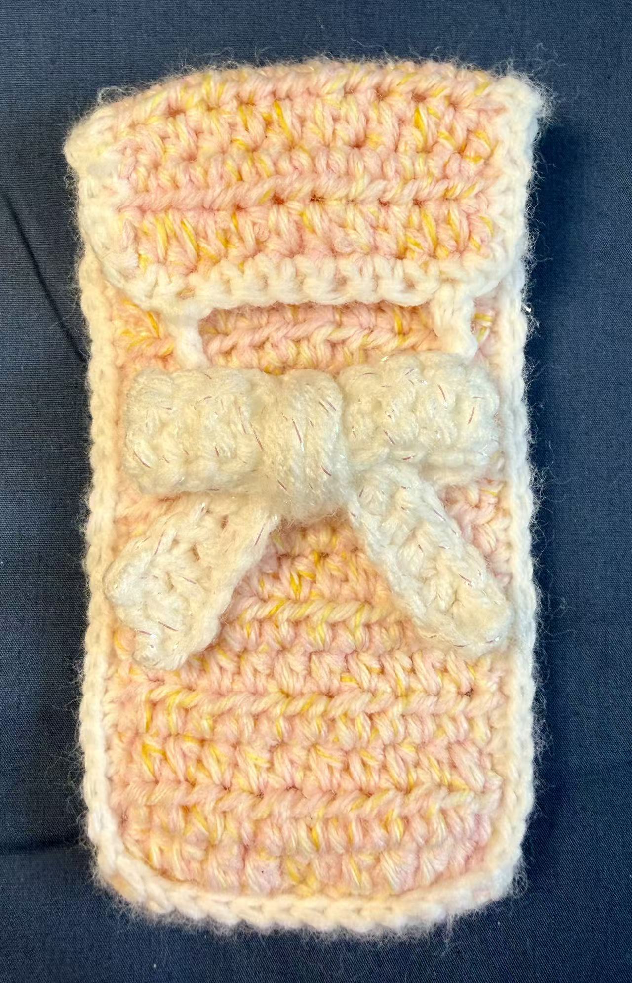 Front view of the closed crochet pencil or glasses pouch with a bow closure.