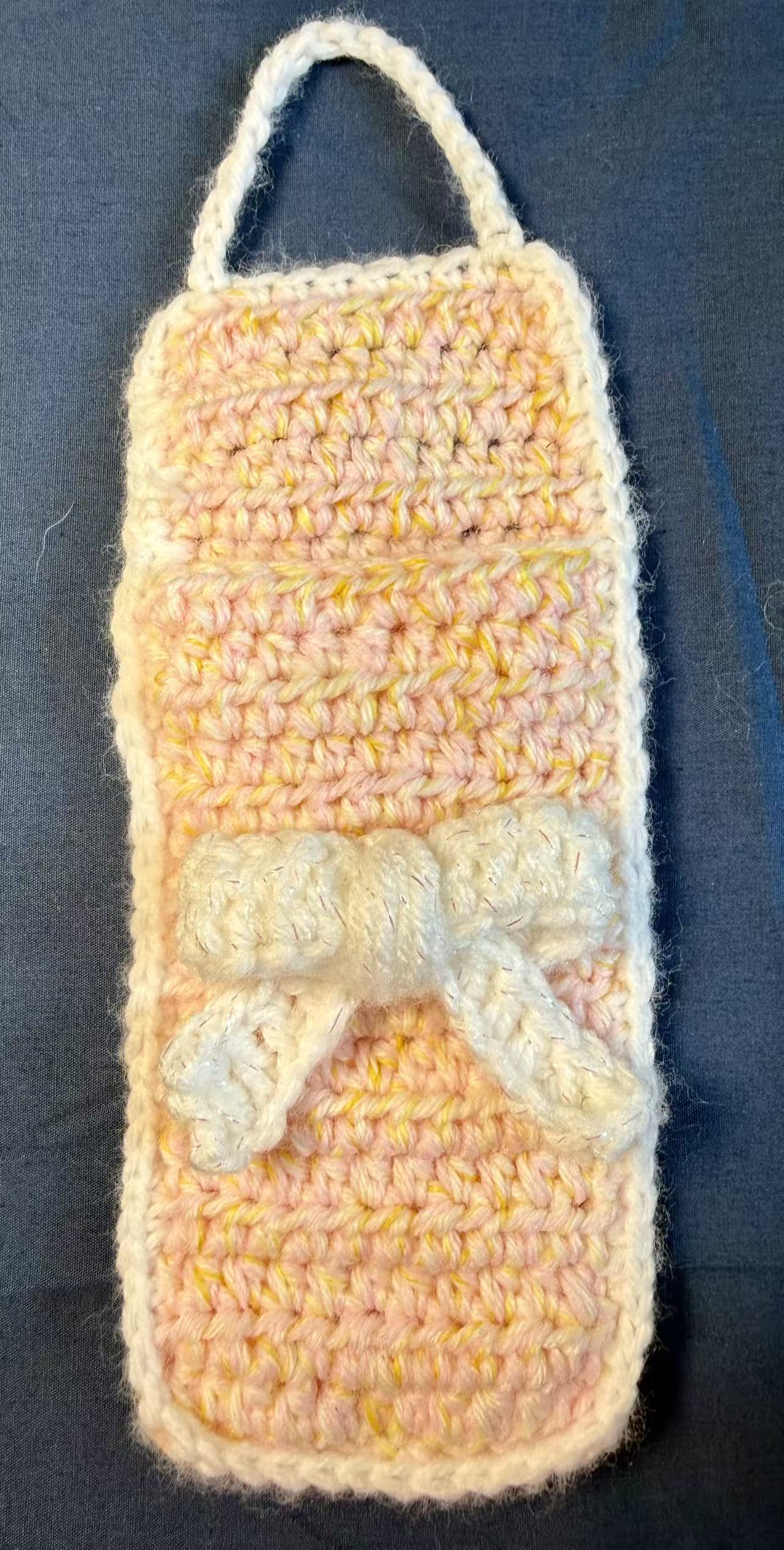 Front view of the crochet pouch with the flap open.